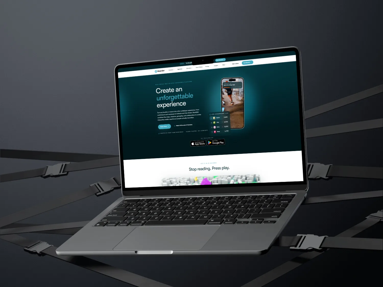The new ReadySet homepage shown on a floating MacBook Air against a dark backdrop of crossing safety straps, with the 'Create an unforgettable experience' hero visible on screen.
